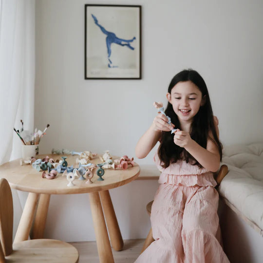 child in bedroom playing with mushi bpa free non toxic siliocone builder suction toys 