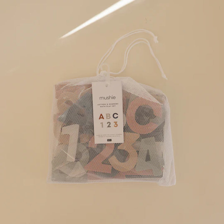 Mushie foam bath alphabet set product shot - uppercase A-Z and 0-9 number pieces arranged in rows on white background