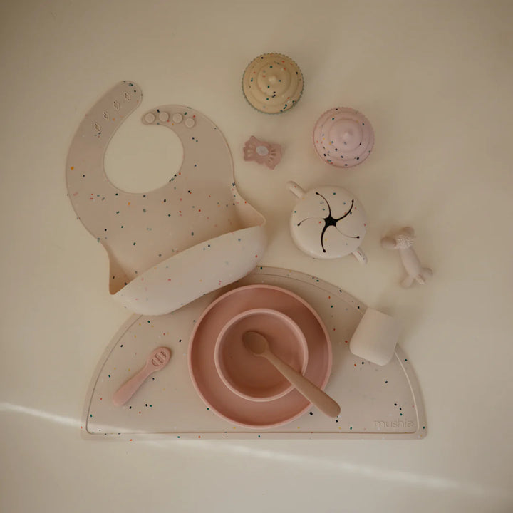 Lifestyle image of Blush Uppababy mushie silicone starter cup, reusable for sustainable feeding.