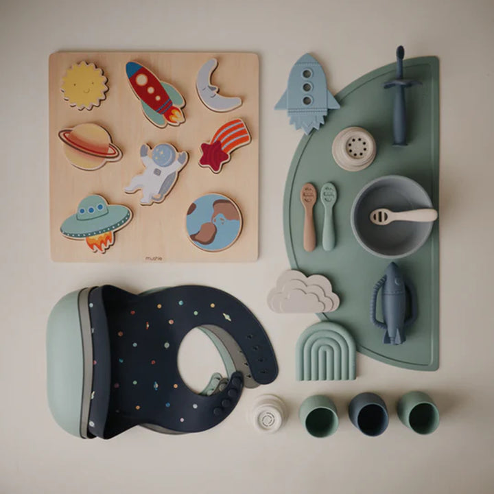 Blush Uppababy mushie silicone starter cup in use, infant safe and made from durable silicone.