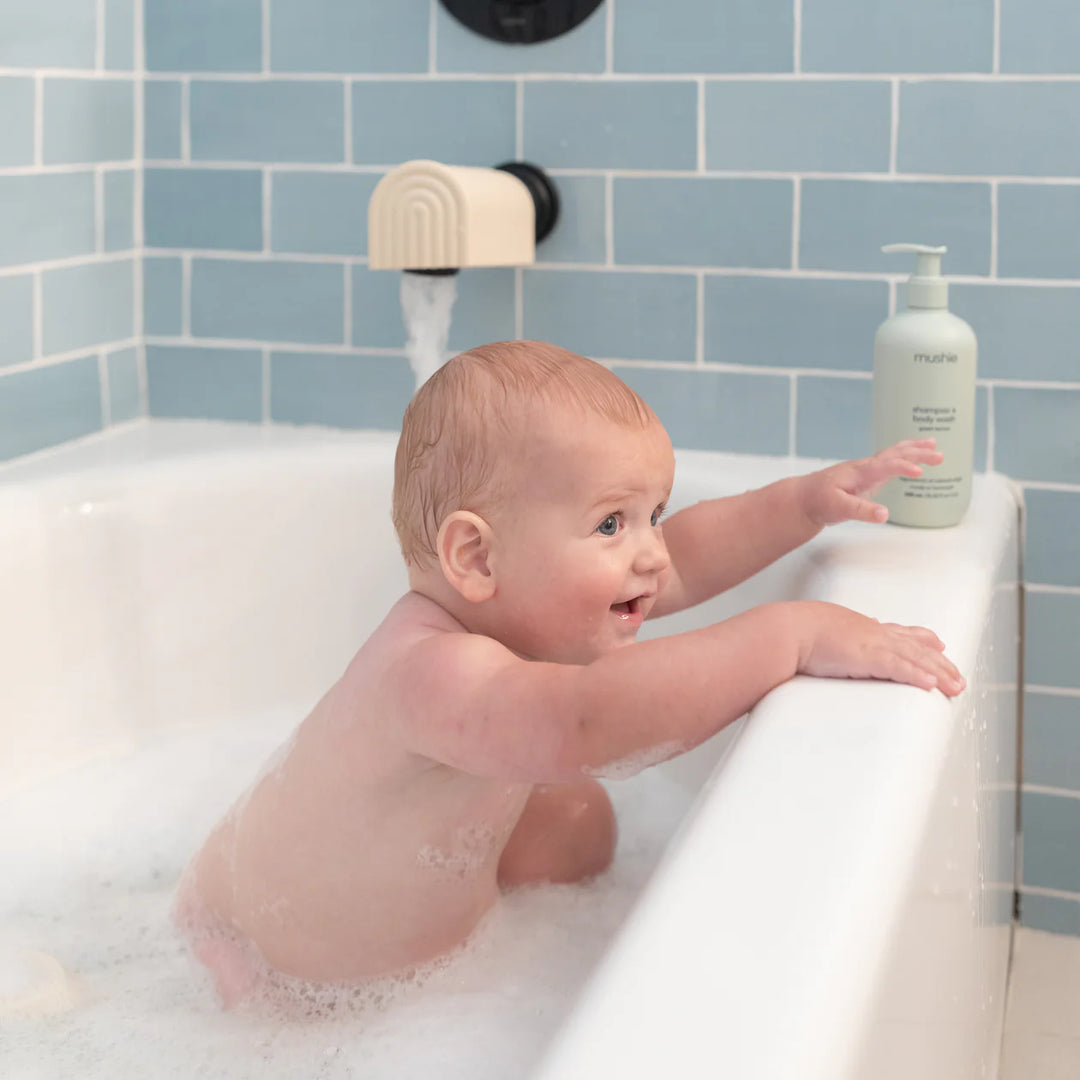 Mushie Dino Bath Essentials Kit lifestyle photo - dinosaur bath toys with colorful Mushie product styling