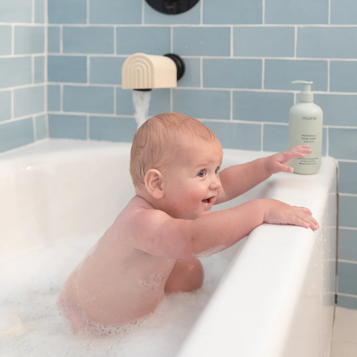 Mushie Dino Bath Essentials Kit lifestyle photo - dinosaur bath toys with colorful Mushie product styling