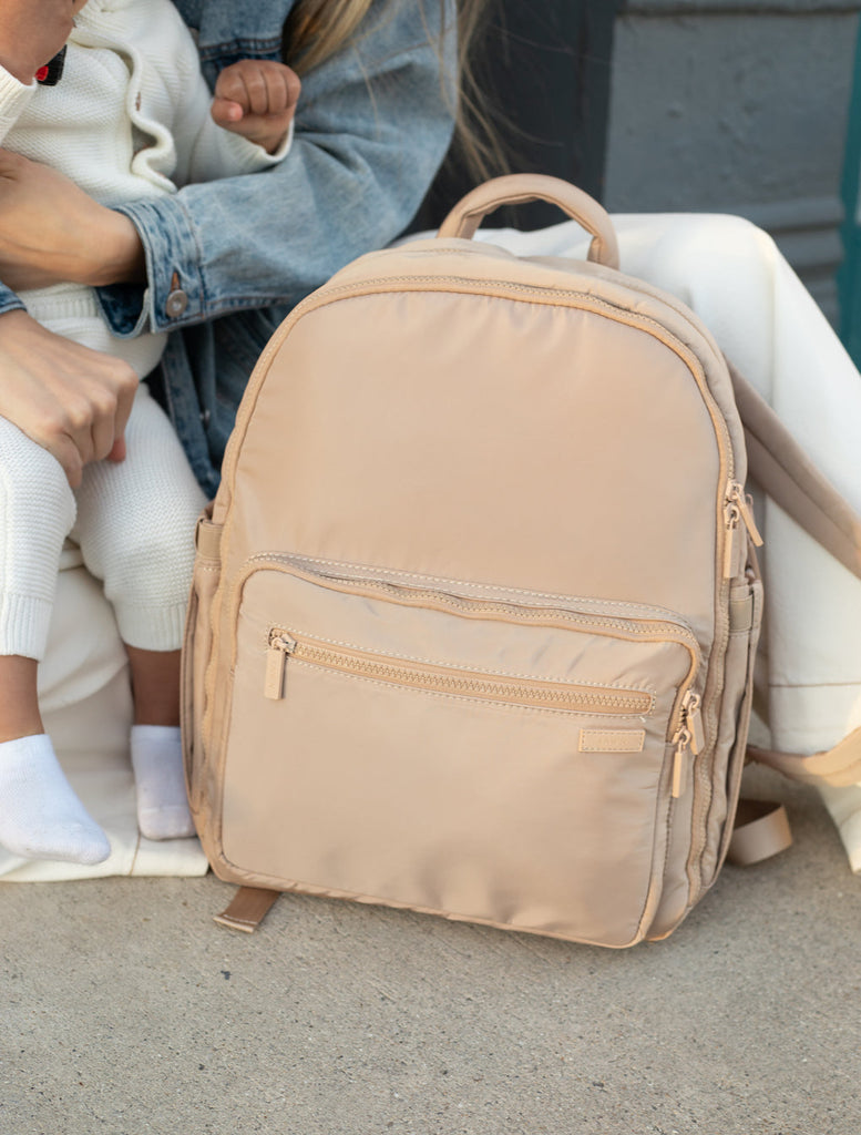 mom sitting with child and fawn design nylon diaper backpack