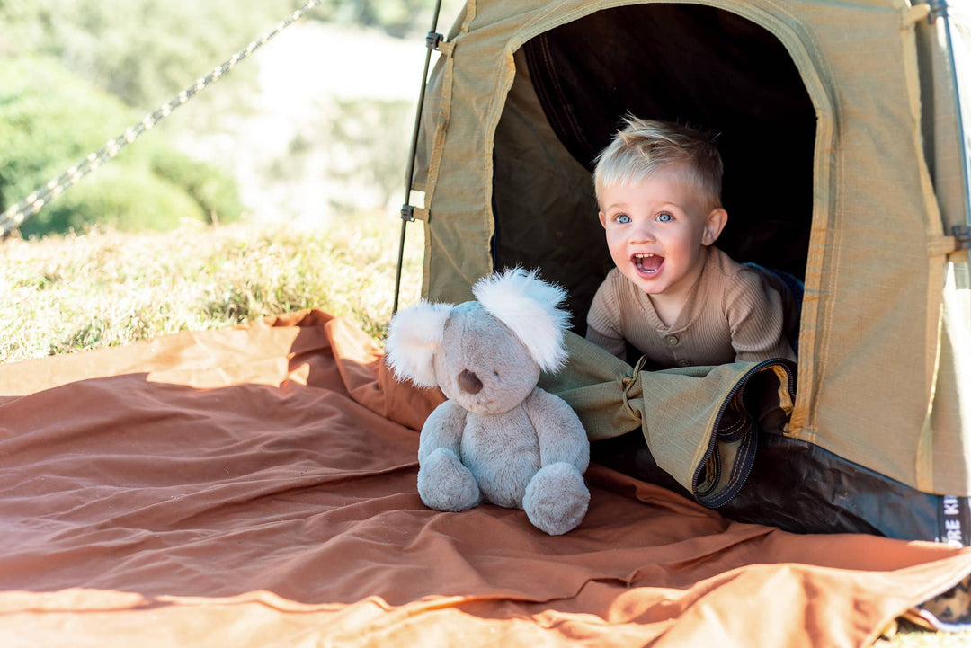 ob desoigns plush kobi kaola stuffed toy with kid in front of tent 