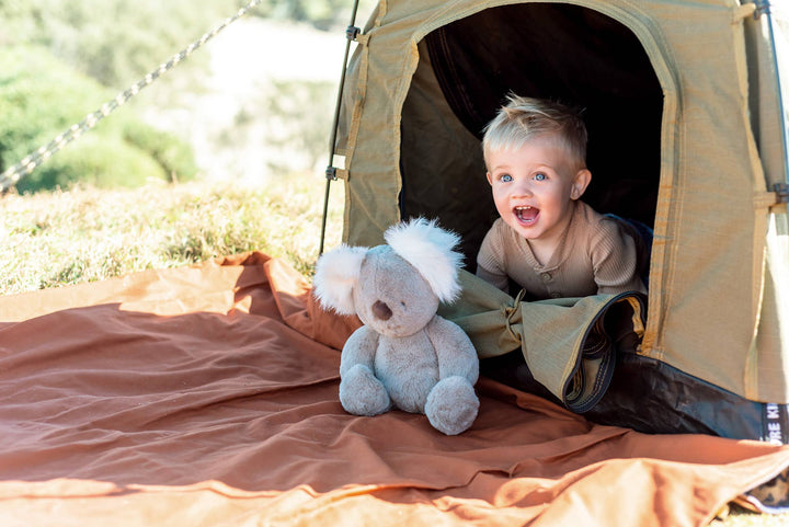 ob desoigns plush kobi kaola stuffed toy with kid in front of tent 