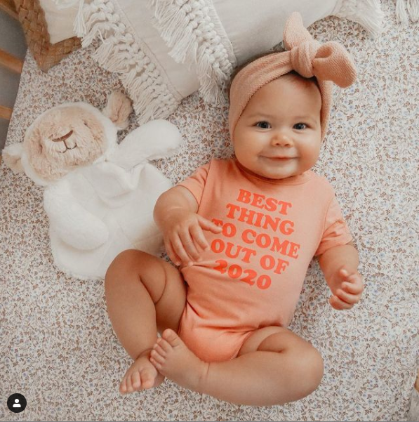 infant laying next to lamb lee infant safe stuffed animal 