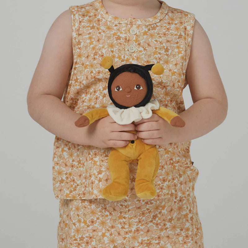 child in yellow floral outfit holding dinky dinkums billie bumblebee ollie ella soft posable baby doll 
