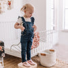 Toddler wearing a pair of pink t-bar organic leather shoes, made by Little Love Bug company.