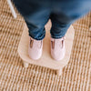 Toddler wearing a pair of pink leather t-bar Little Love Bug co. shoes.