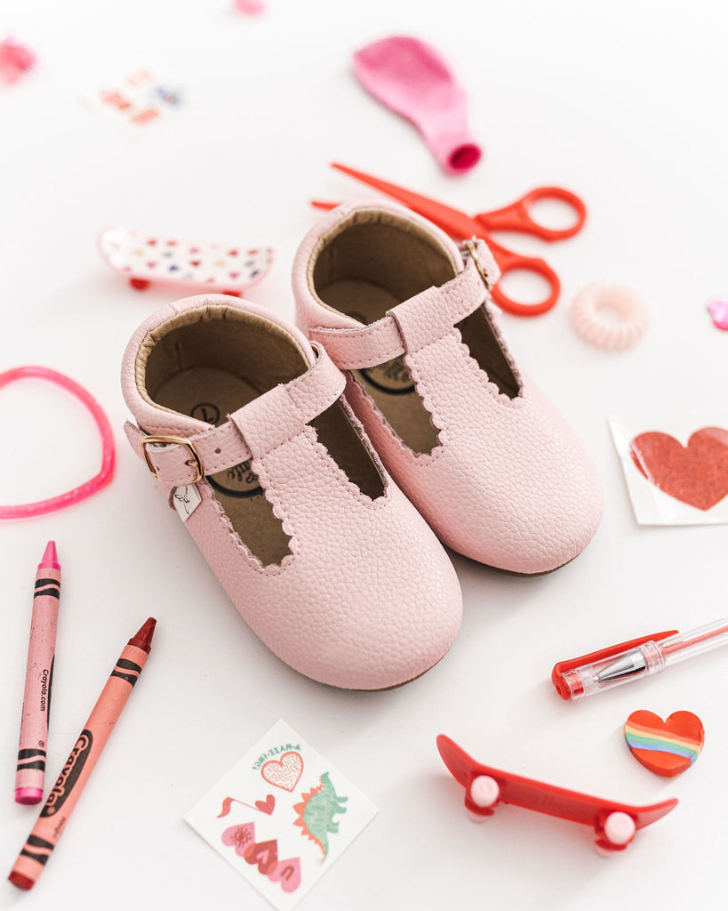 Little Love Bugs Company pink leather t-bar shoes on a white background.