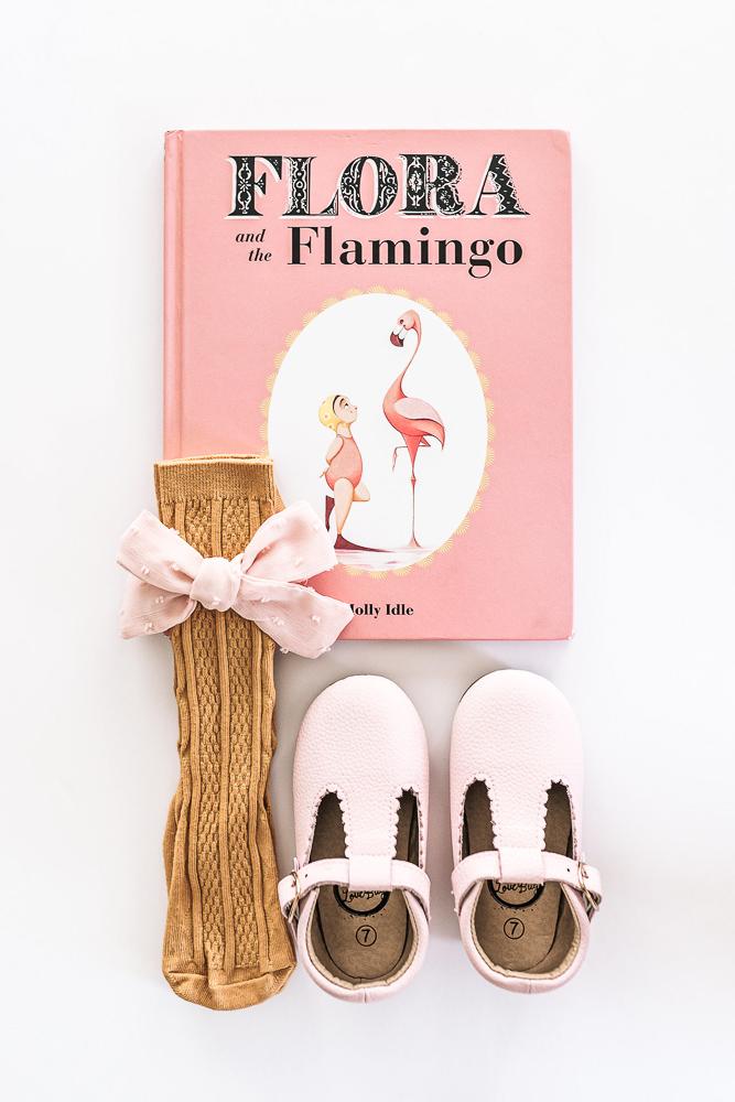 A book, socks and a pair of soft soled Little Love Bug pink shoes.