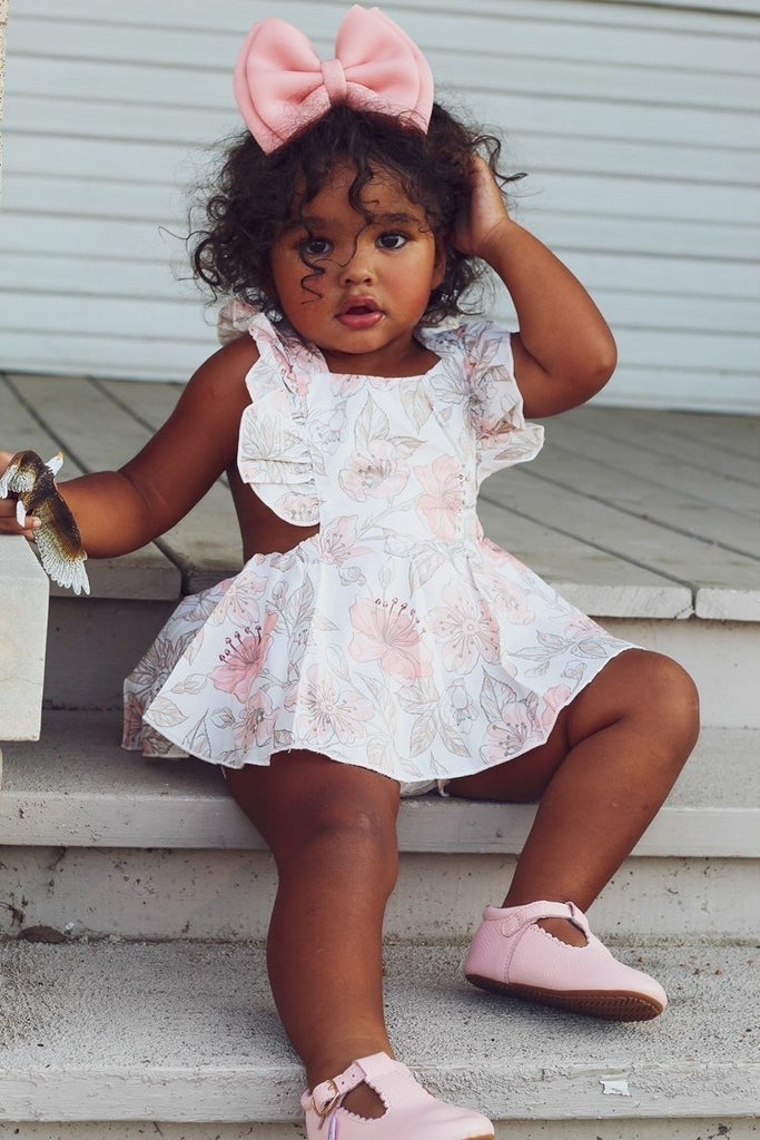 Little girl wearing a pair of Little Love Bug organic leather shoes in pink.