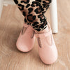 Organic Little Love Bug pink t-bar shoes being worn by a toddler.