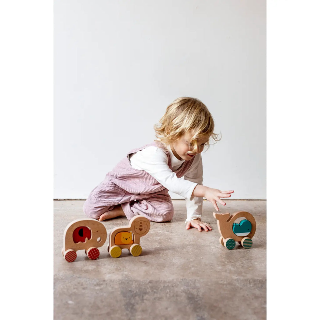 little girl playing with petitecollage push and pull toys