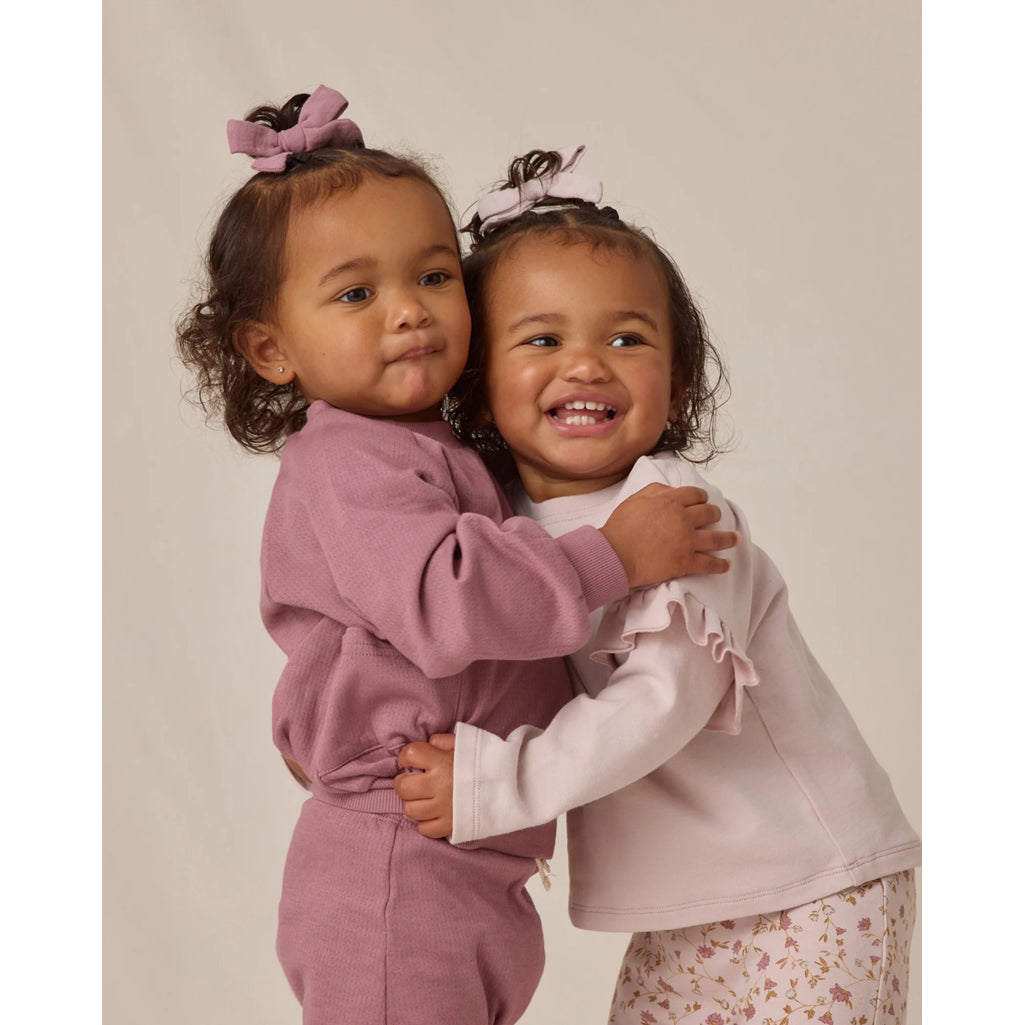 two toddler girls wearing quincy mae bow clips in mulberry and purple 