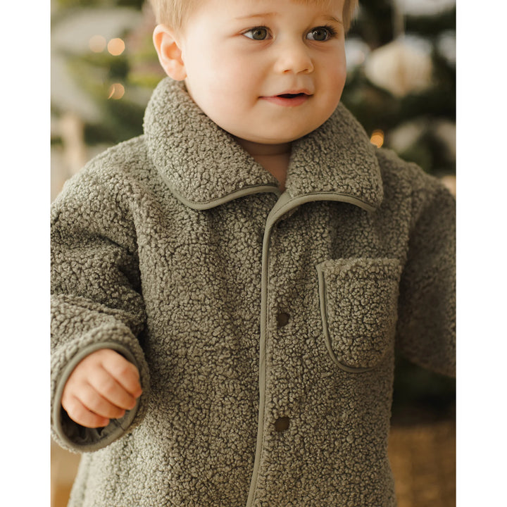 close up of button details on green shearling quincy mae warm jumpsuit for infant 