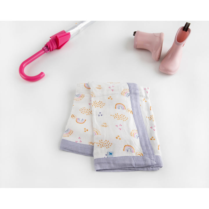 Adorable Little Unicorn Deluxe Muslin Quilt - Rainbows & Raindrops, perfect as a soft baby quilt for playtime or rest.