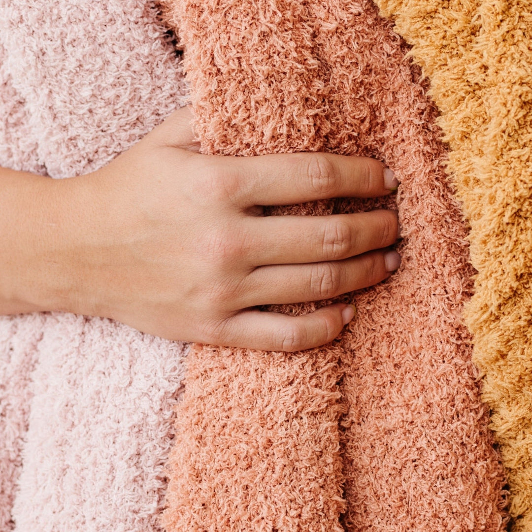 Snuggle-ready Saranoni Ribbed BAMBONI¨ Blanket shown in various colors, one of the best blankets for toddlers.