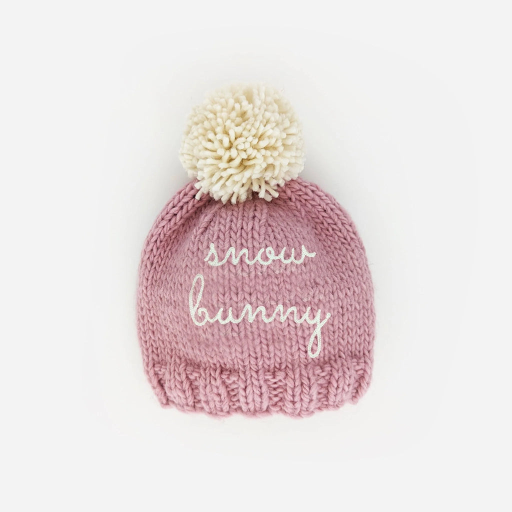 Huggulugs Snow bunny beanie hat in Rosy pink with white pompom and text saying snow bunny 