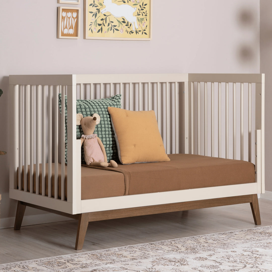Close view of the Dadada Soho 3-in-1 Convertible Crib in almond milk walnut finish presented as a 3 in 1 crib.