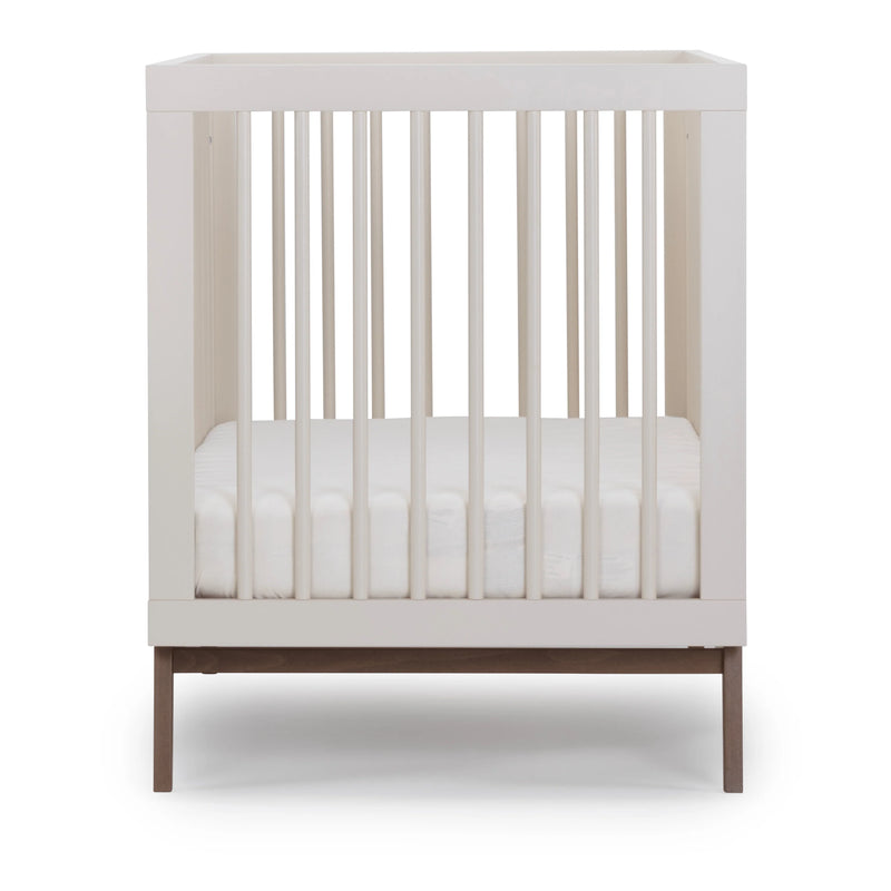 Modern nursery look with the Dadada Soho 3-in-1 Convertible Crib in almond milk walnut shown as a baby crib.
