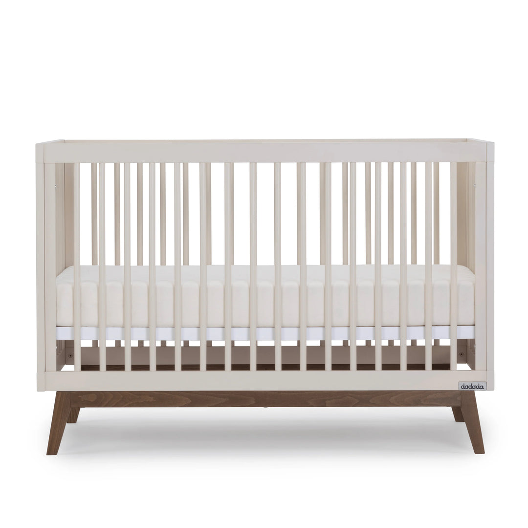 Detailed shot of the Dadada Soho 3-in-1 Convertible Crib in almond milk walnut highlighted as a best crib choice.