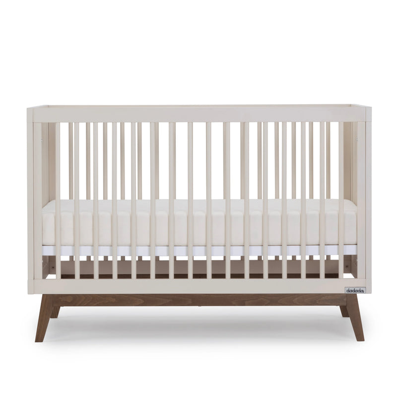 Detailed shot of the Dadada Soho 3-in-1 Convertible Crib in almond milk walnut highlighted as a best crib choice.