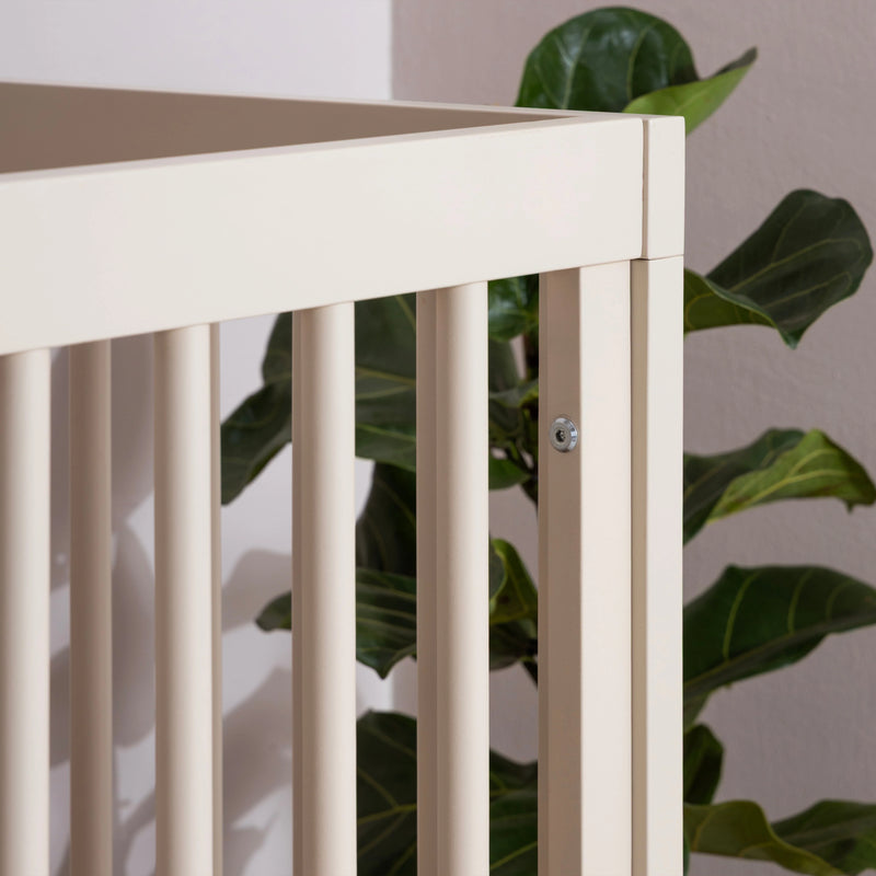 Angled design of the Dadada Soho 3-in-1 Convertible Crib in almond milk walnut shown as a baby cribs style.