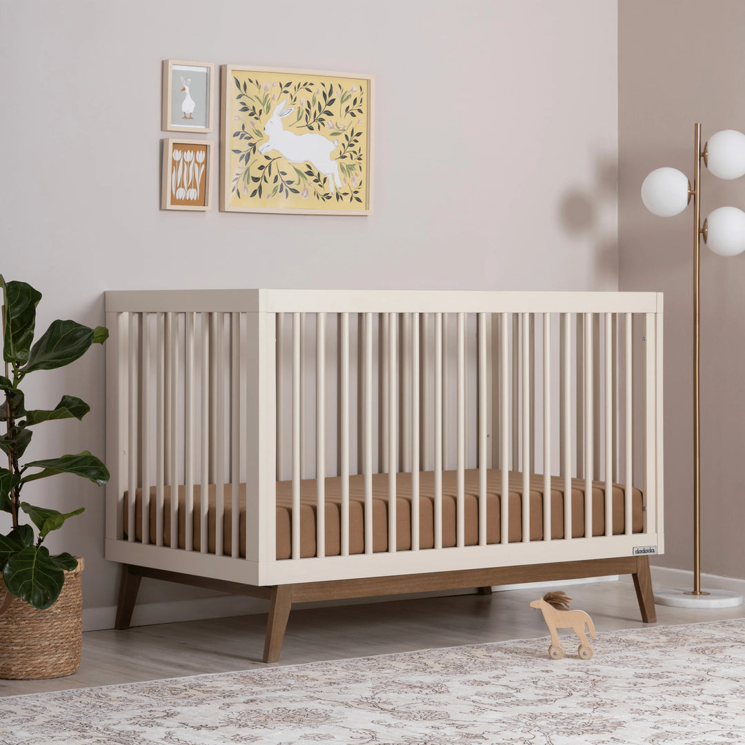 Stylish Dadada Soho 3-in-1 Convertible Crib in almond milk walnut featured as a best cribs option.