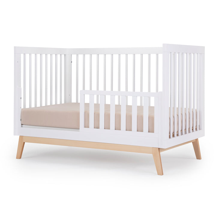 Toddler bed setup of the Dadada Soho 3-in-1 Convertible Crib in white and natural shown as a crib wood style.
