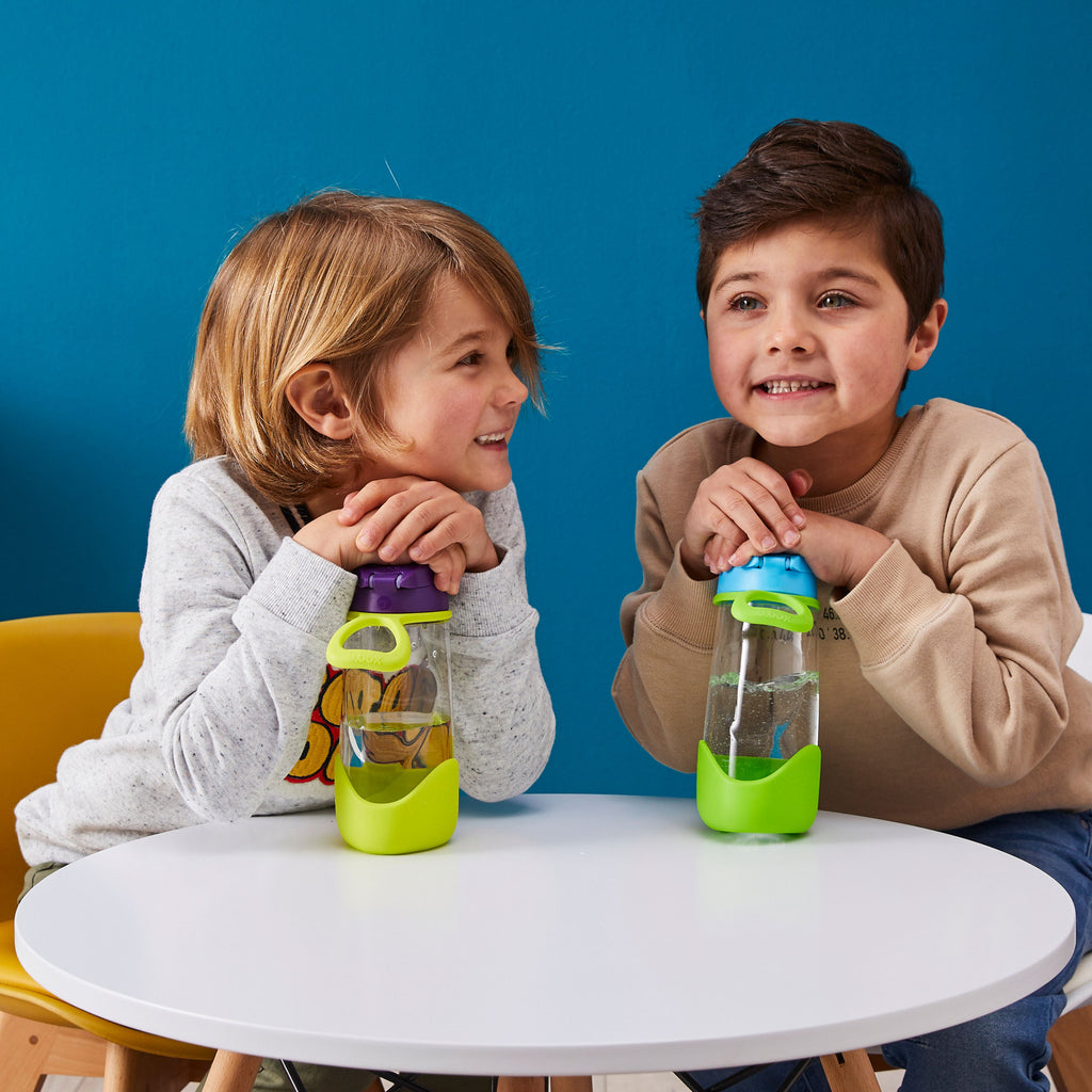 children holding two bbox sport spout bottles at table