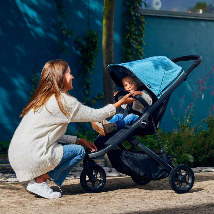 Thule Spring Bumper Bar lifestyle – toddler secured in Thule Spring stroller with bumper bar installed