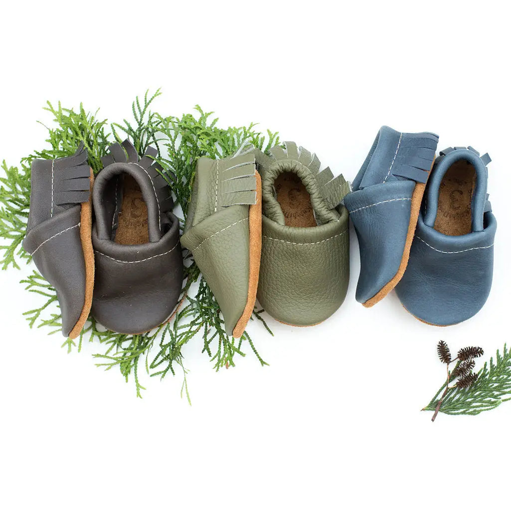 row of three pairs of soft adjustable hand crafted baby shoes leather designed with no slip soles by starry night design 