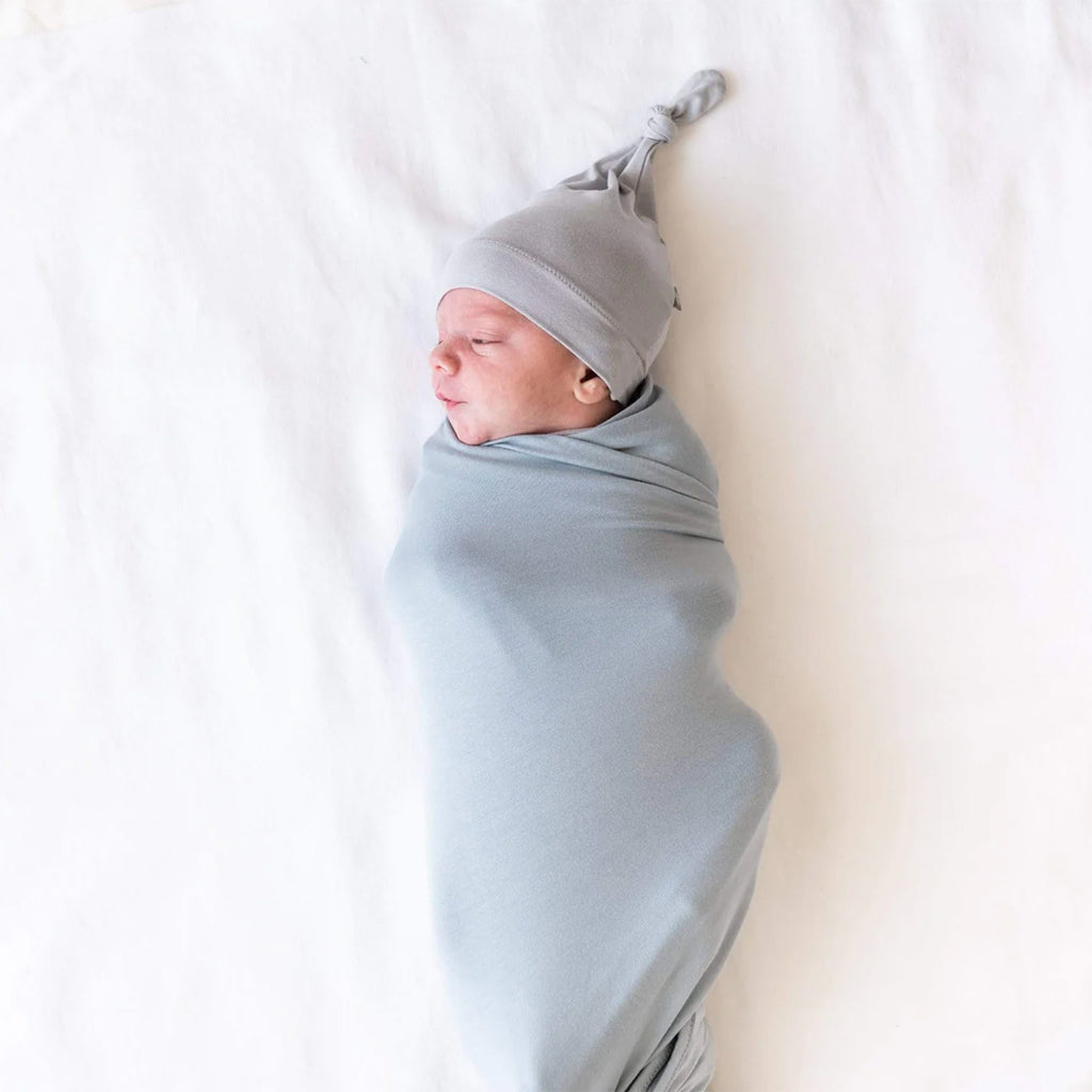 baby swaddled and wearing Kyte Baby knotted caps