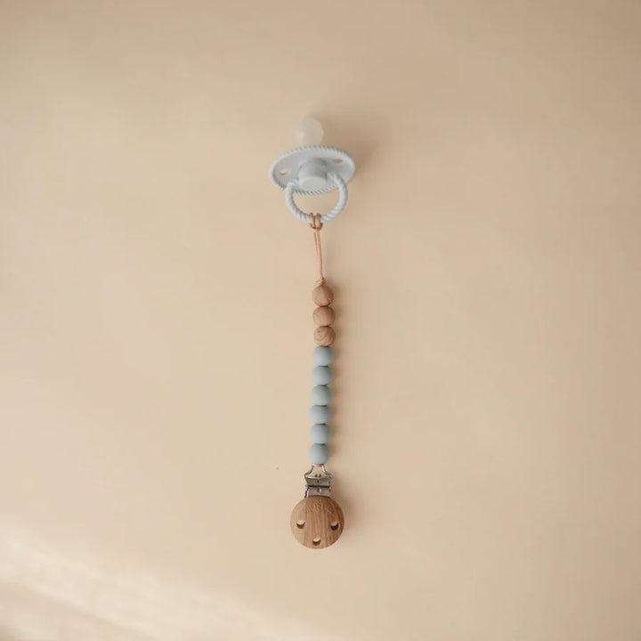 Mushie Eva Pacifier Clip in Cloud ensuring your baby's pacifier stays clean and secure throughout the day