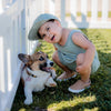 Boy wearing Tan Quinn little love bug shoes next to dog.