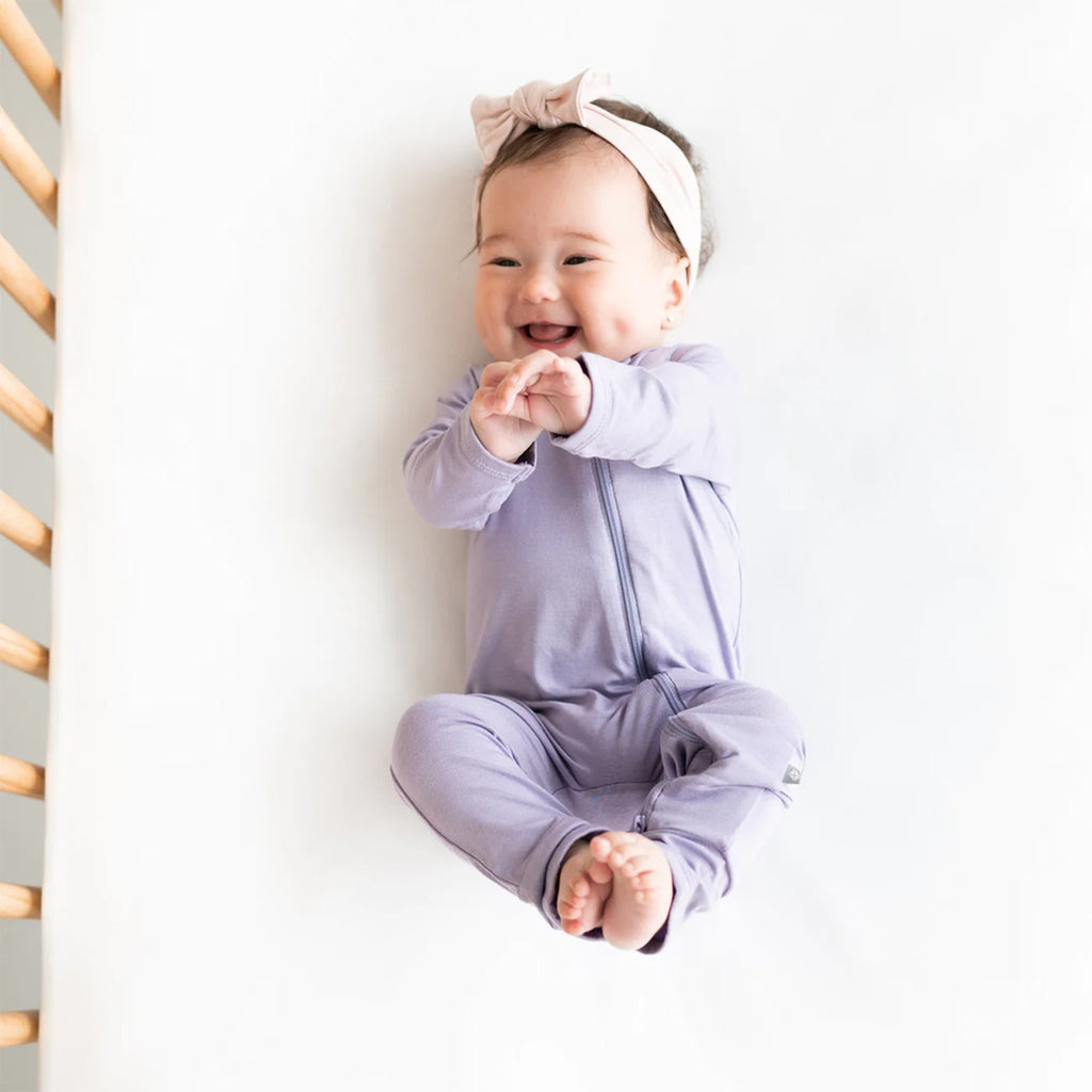 Happy baby in the adorable Kyte Zipper Romper in the shade Taro.