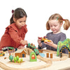 toddlers playing with natural wood train track kit