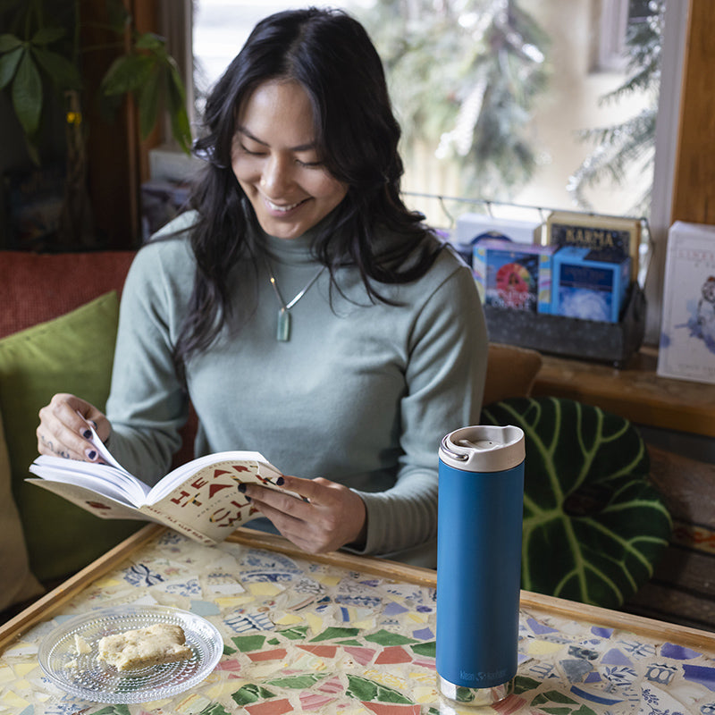 Woman reading with Corsair Klean Kanteen 20oz TKWide with Cafe Cap, dishwasher safe and leak proof.