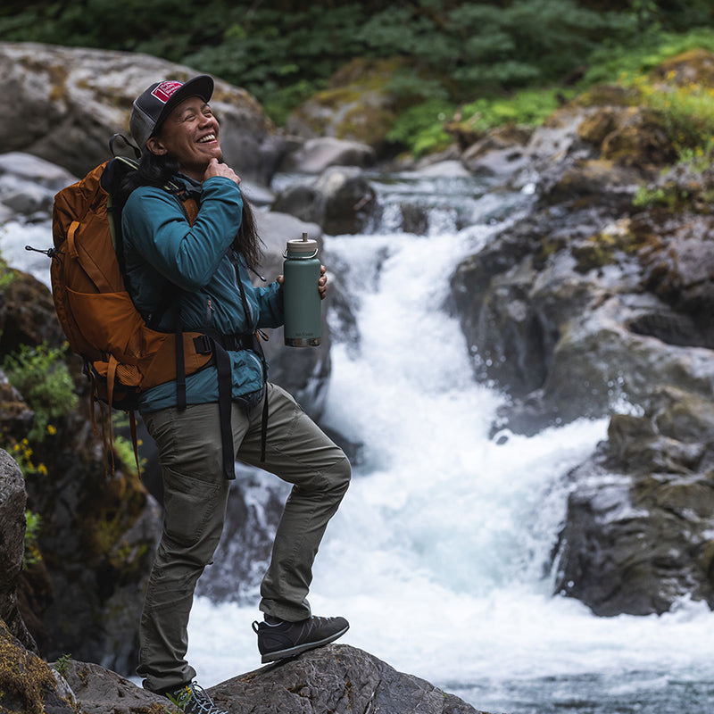 Traveler carrying Klean Kanteen 32oz TKWide with Twist Cap in Sea Spray, showing easy to clean and portable build