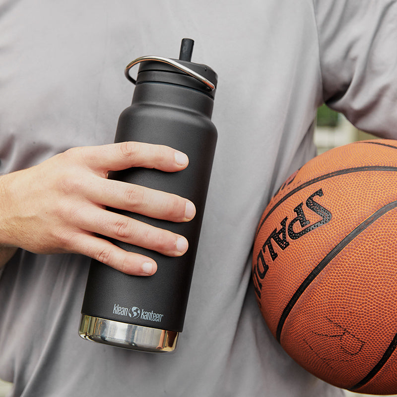 Close-up of Klean Kanteen 32oz TKWide with Twist Cap beside basketball, featuring durable stainless steel construction