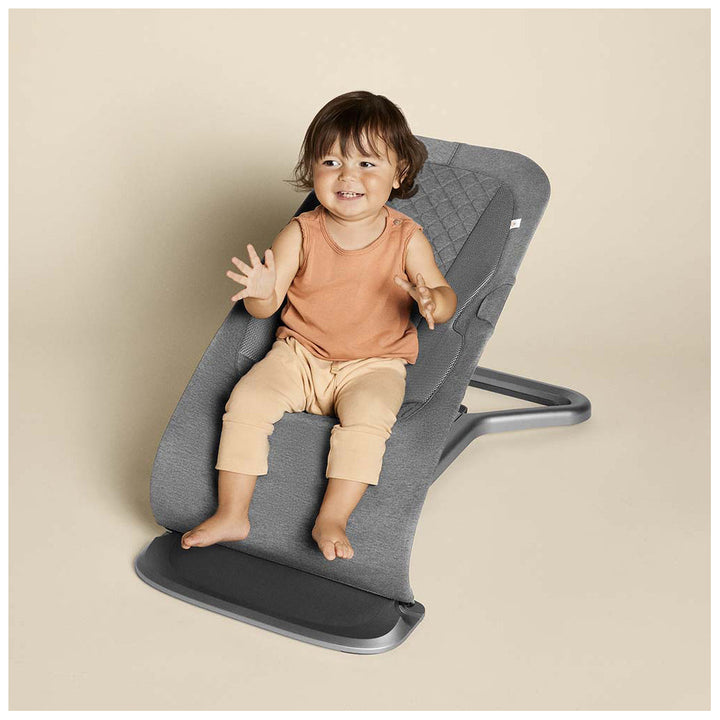 Toddler sitting in the ergobaby evolve baby bouncer chair 