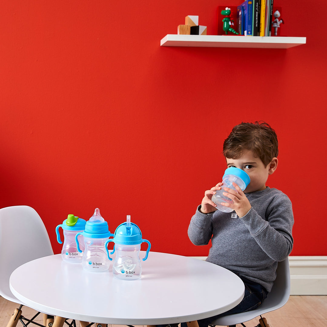 toddler drinking from blueberry sippy cup with transition pieces