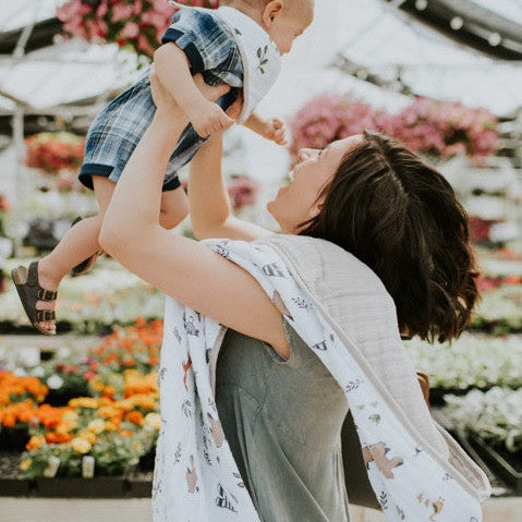 Little Unicorn Original Cotton Muslin Quilt - Forest Friends styled with matching bib, a charming baby quilt for cozy nursery comfort.