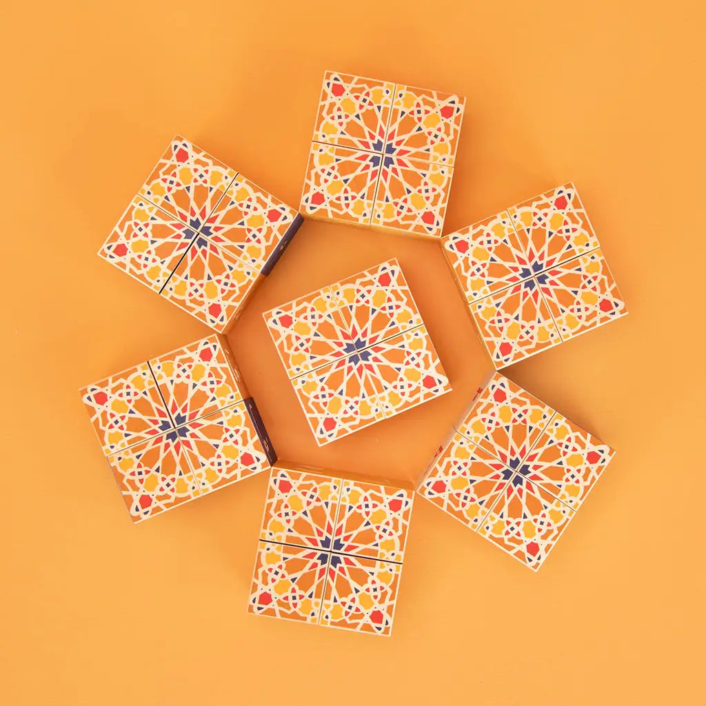 Wooden kid's toy in cube form with mosaic design laid out on plain yellow background. 