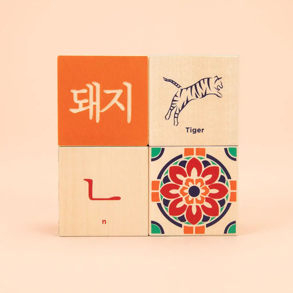 Korean toddler handcrafted block set showing four cubes stacked in groups of two, with an orchid illustration on one and an illustrated tiger on the other. 