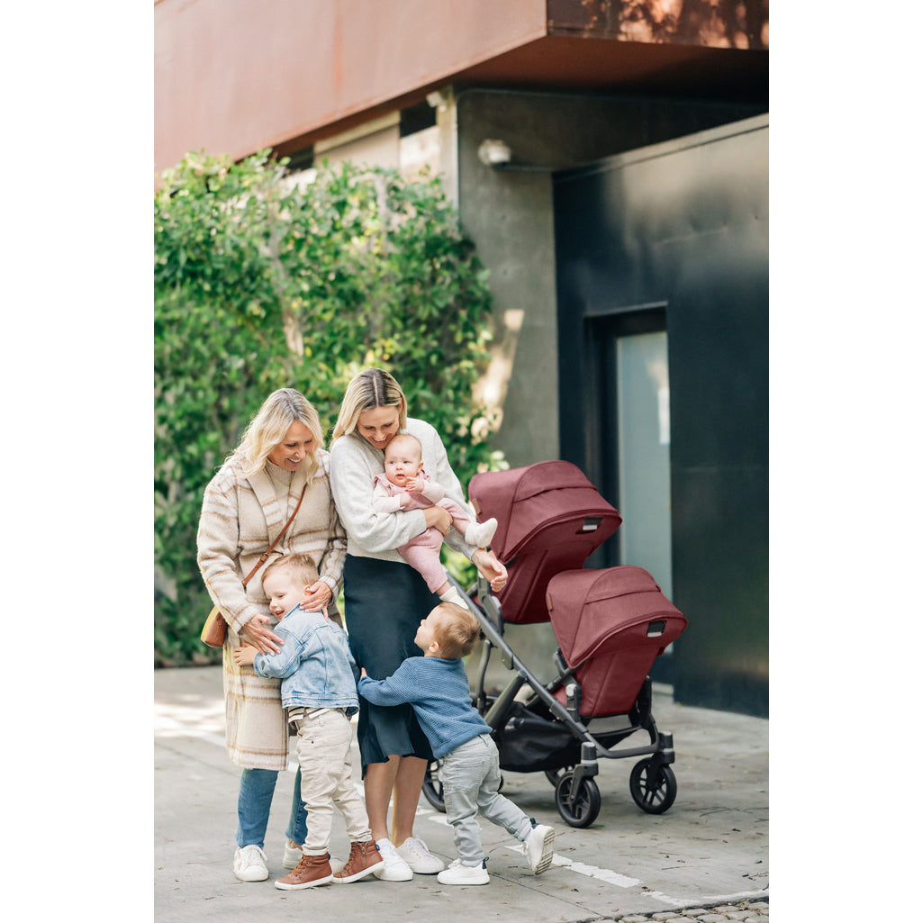 Parents strolling with the UPPAbaby Vista V3 Twin Double Stroller in Jake, a durable double stroller for everyday use