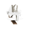 A close up of the white nomi highchair seat with harness.