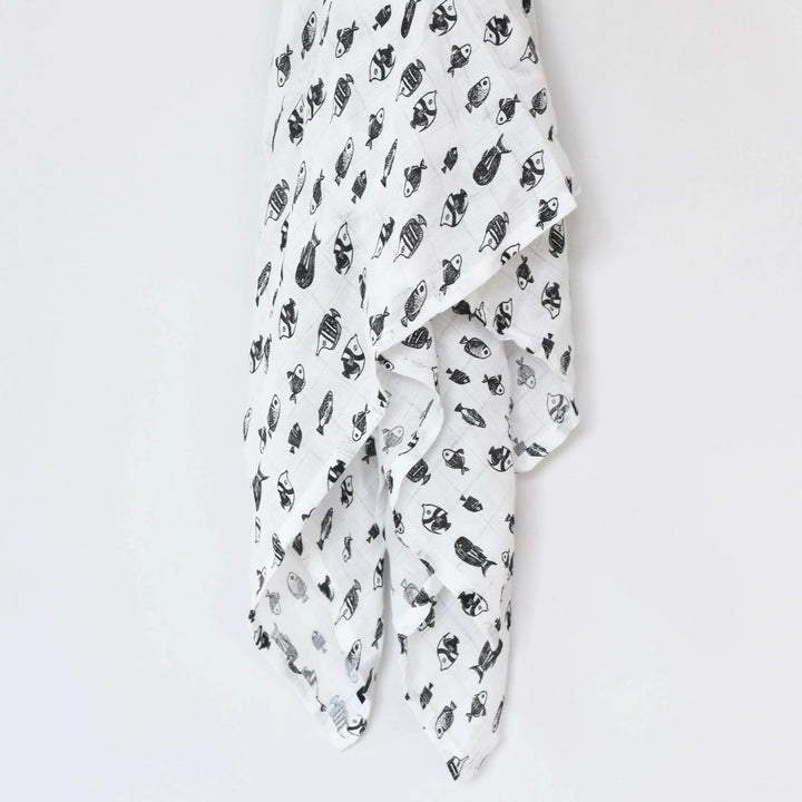 Black and white fish print organic muslin swaddle by Wee Gallery, draped to show the lightweight, breathable weave