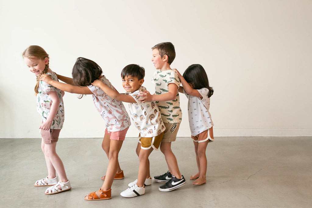 Kids wearing the white and black little love bug sneakers.